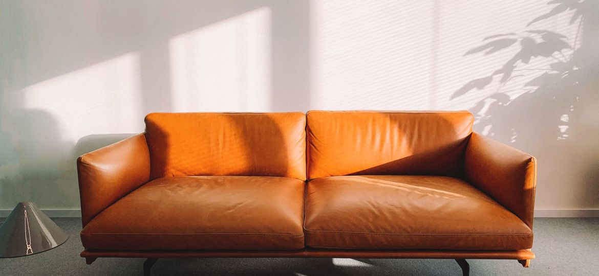 2-seat-orange-leather-sofa-beside-wall-1866149