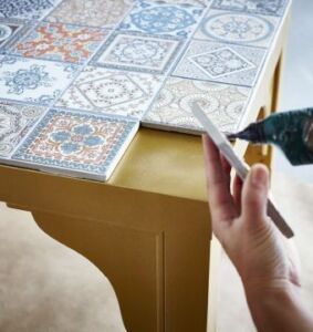 Hot gluing tiles onto a table.